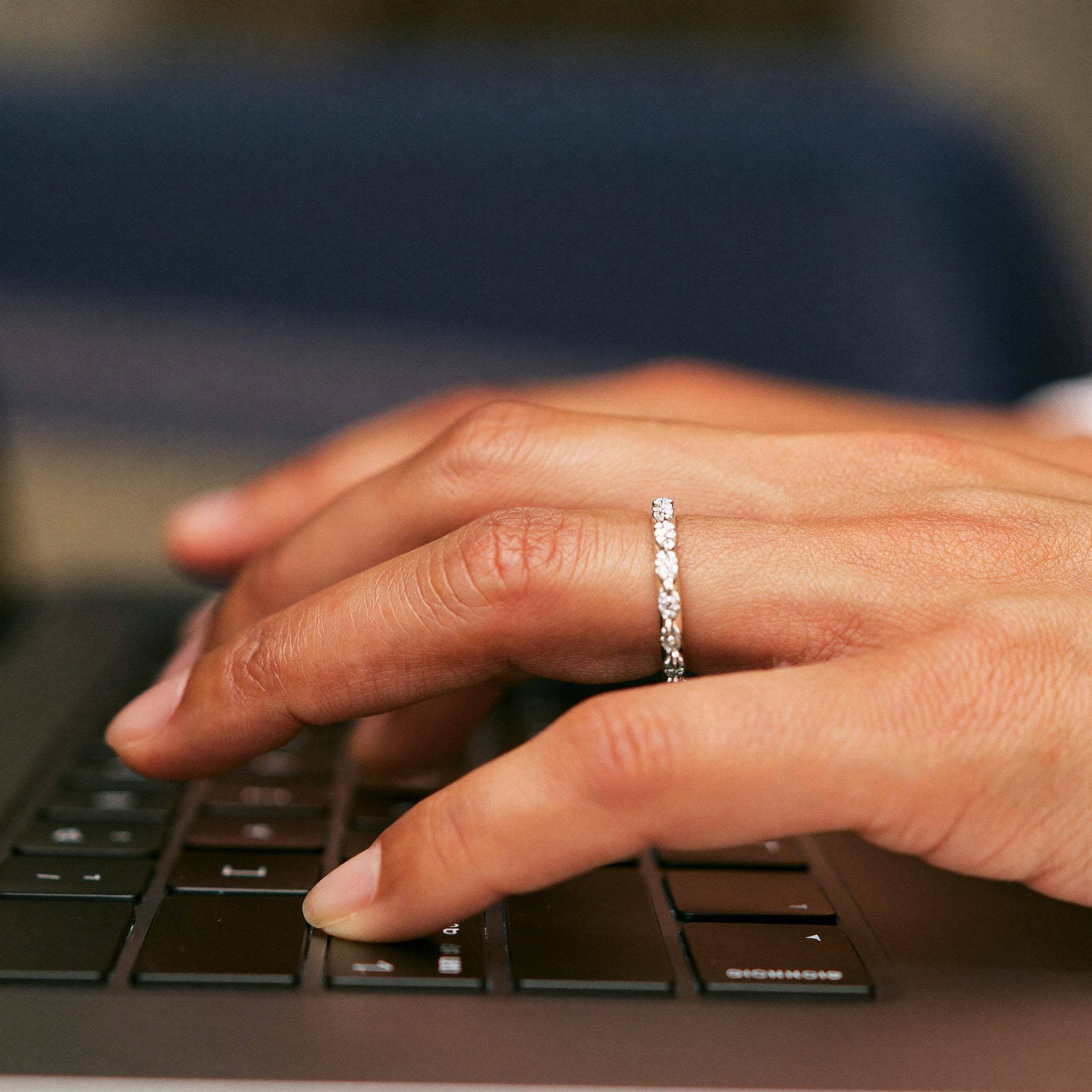 Mains d'une personne mature sur un clavier d'ordinateur