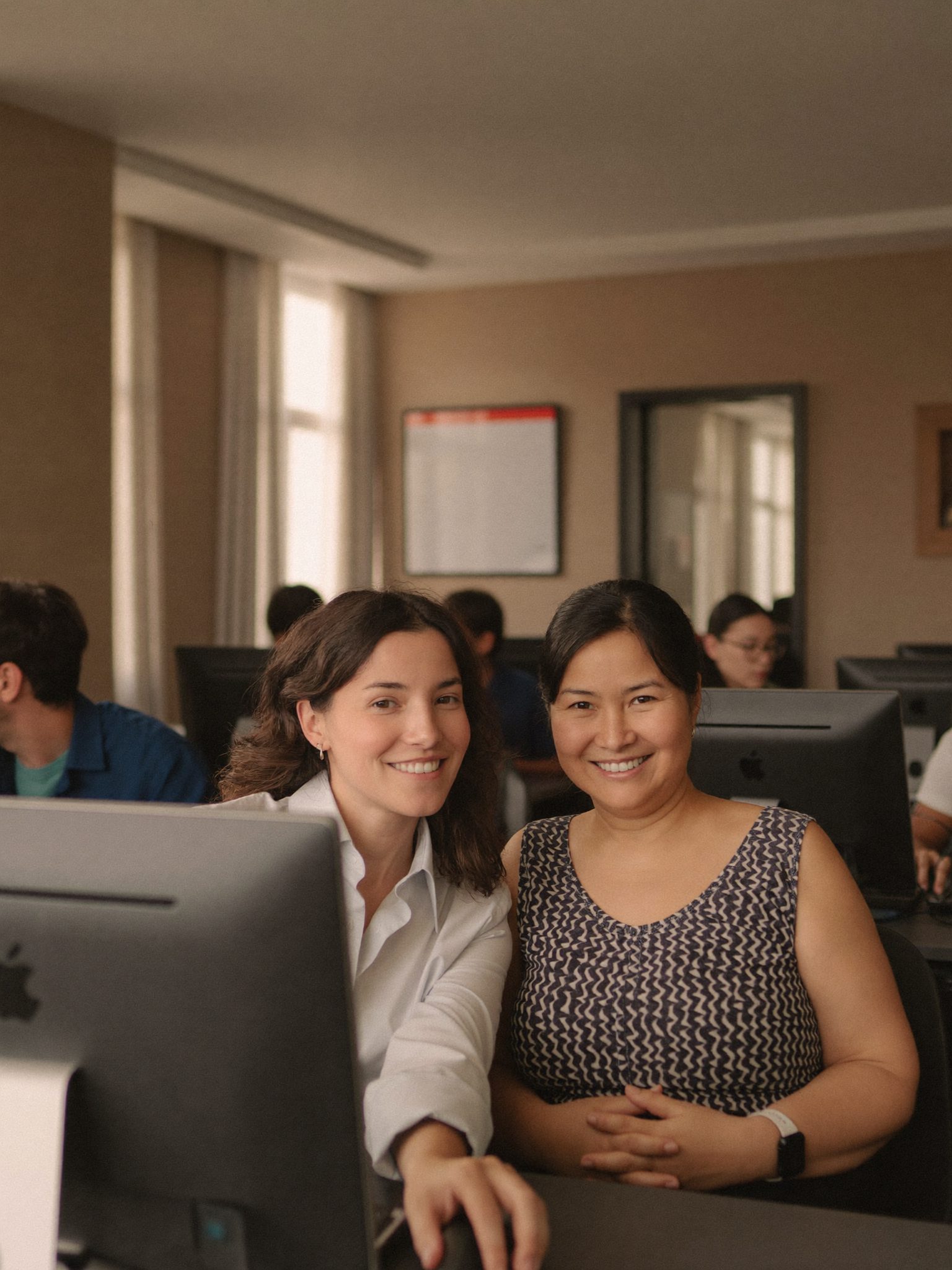 Hélène Marchetti, gérante, assise à côté d'un élève devant un ordinateur portable